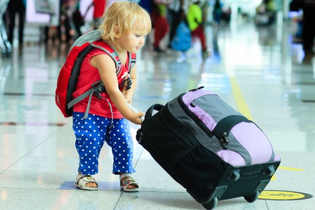 IN-little-girl-with-suitcase-travel-in-the-airport.jpg